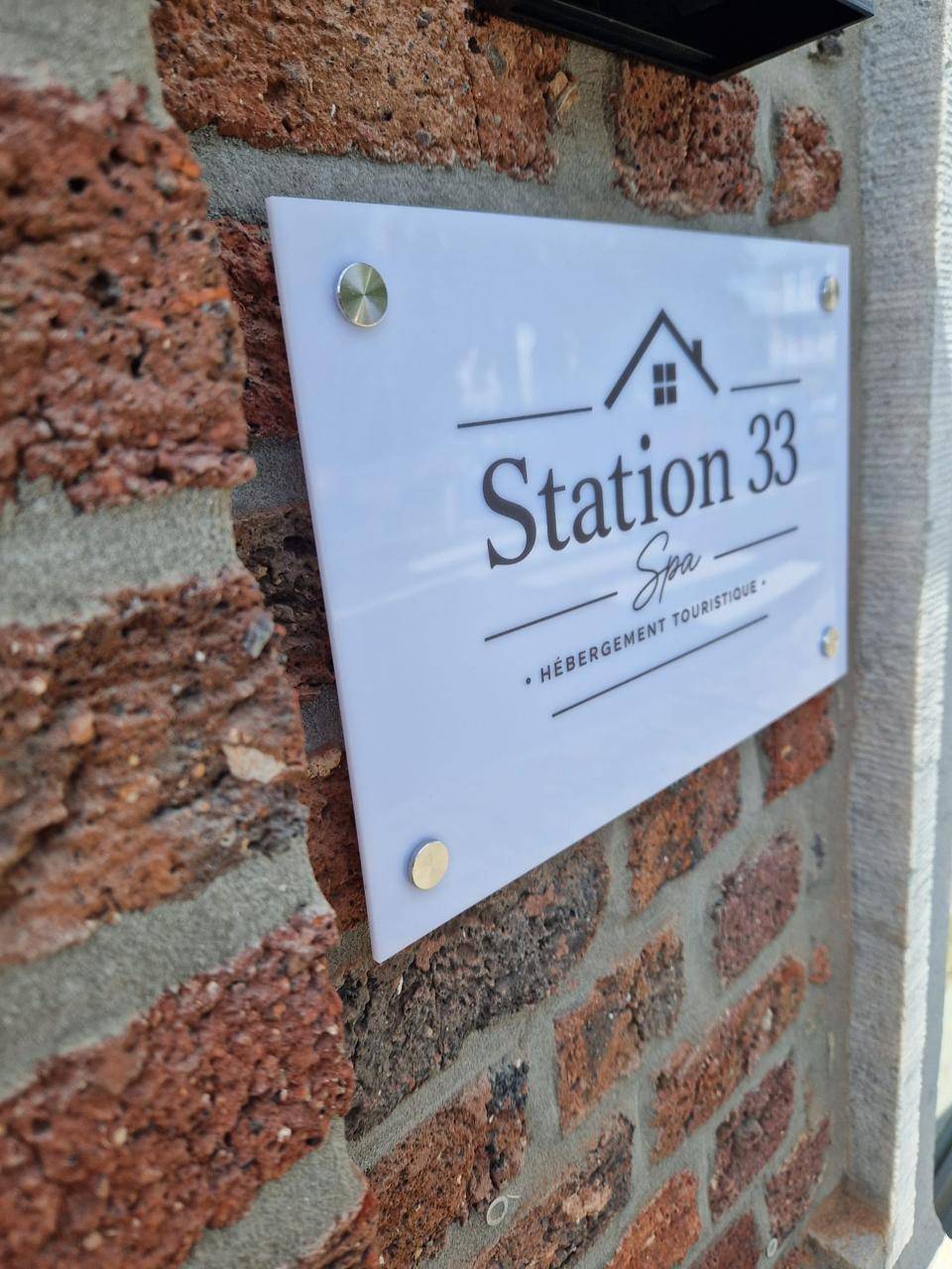 La plaque Station 33 sur la façade en brique