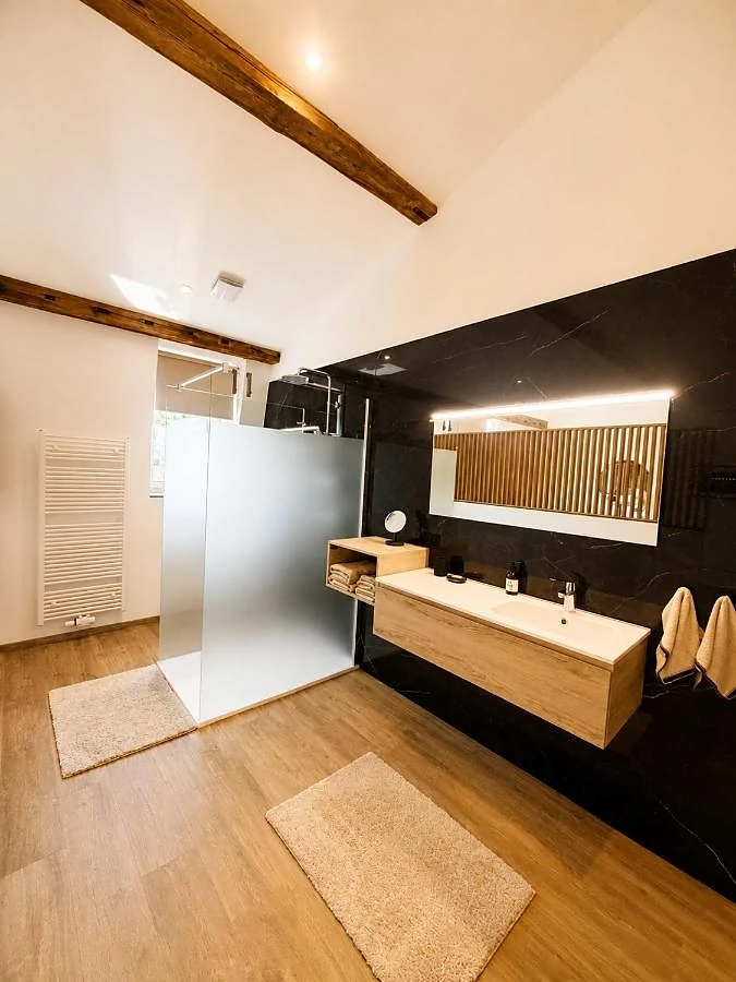 Badezimmer mit Fliesen in schwarzer Marmoroptik und Doppelwaschbecken